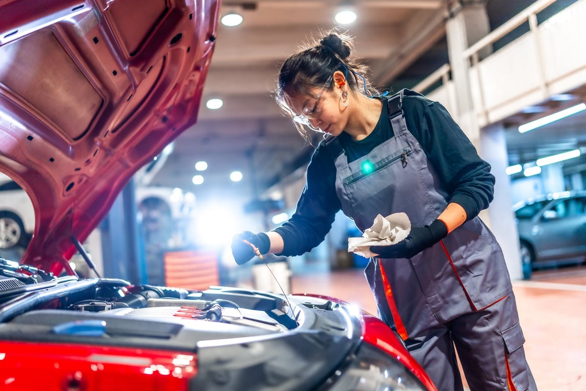 Mechanic checking the oil level of a car engine in a garage