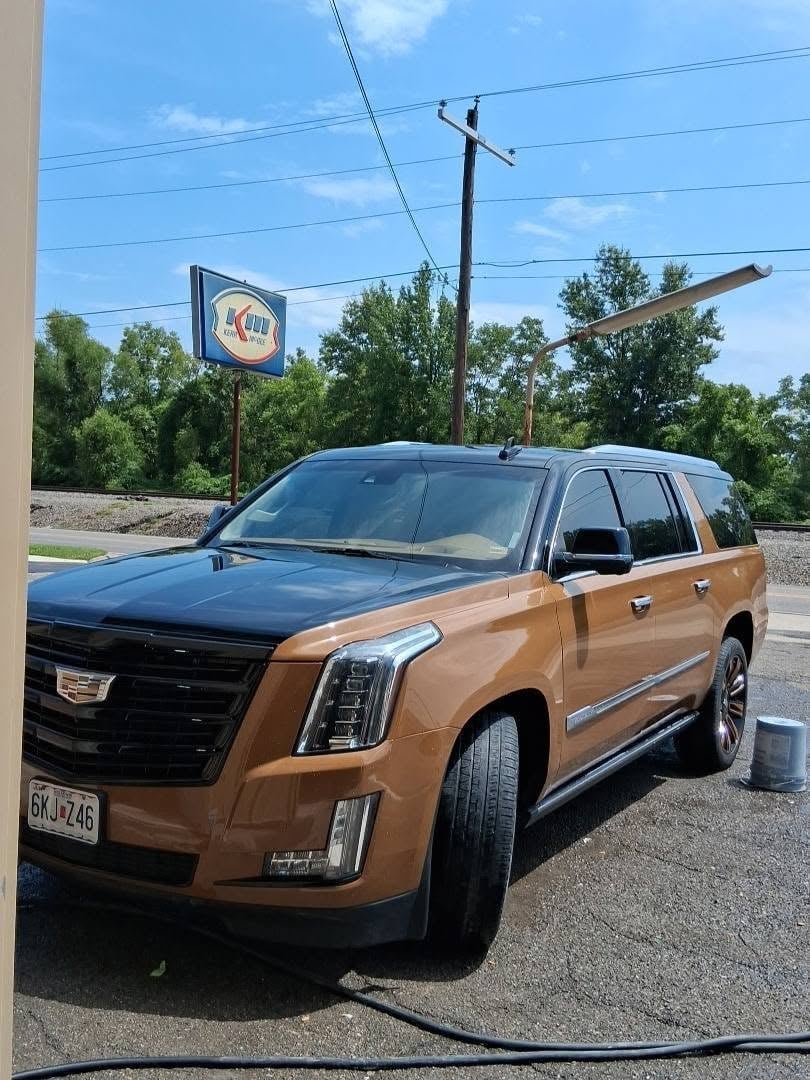 Cadillac Escalade finished in a bronze two-tone paint job outside the shop